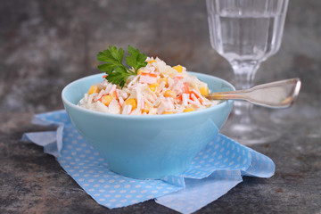 salad of corn crab sticks and cabbage in a blue plate