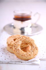bagel with sesame seeds and a cup of tea on a white background