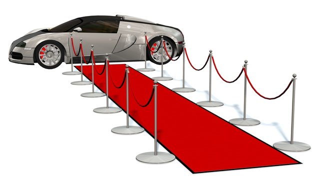 uxury car and silver stanchions and a red carpet