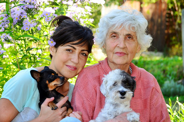 happy family with white poodle dog and black pincher 