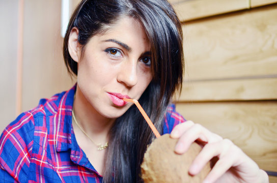 beautiful young woman  drinking fresh coconut juice from a straw