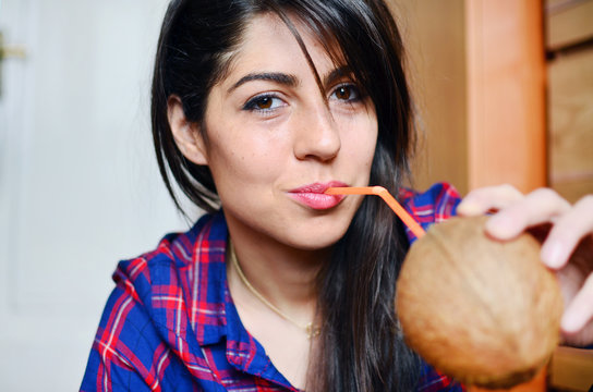 beautiful young woman  drinking fresh coconut juice from a straw