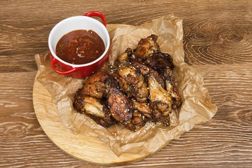 Chicken wings with  sauce on wooden table.