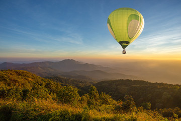 Fototapeta premium Hot air balloon above high mountain at sunset