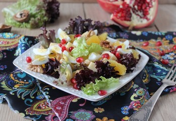 salad with quail eggs, cheese, pomegranate, orange