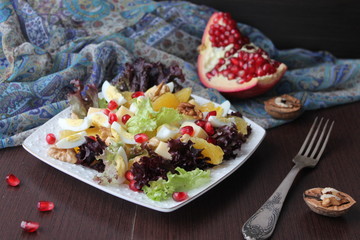 salad with quail eggs, cheese, pomegranate, orange