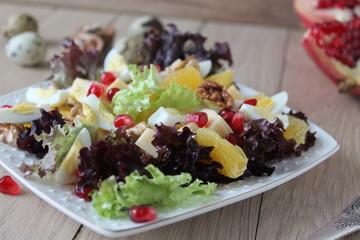 salad with quail eggs, cheese, pomegranate, orange