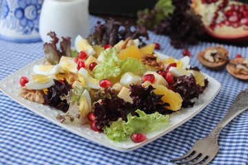 salad with quail eggs, cheese, pomegranate, orange