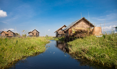 Fototapeta na wymiar Houses and floating gardens at one of Inle Lake villages on the water in Myanmar.