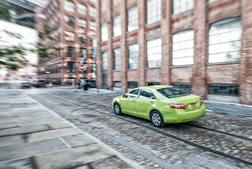 Green taxi speeding up in Brooklyn, New York City