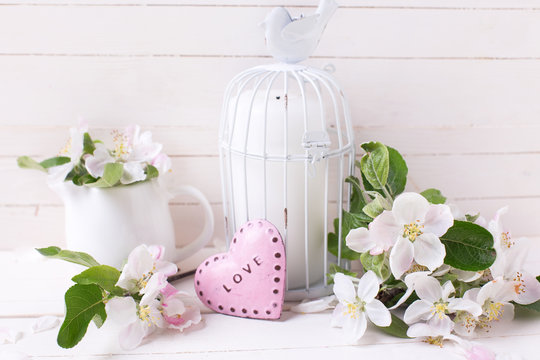 Spring apple blossom, candle in decorative bird cage  and little