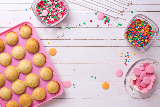 Making cake pops on white wooden background.