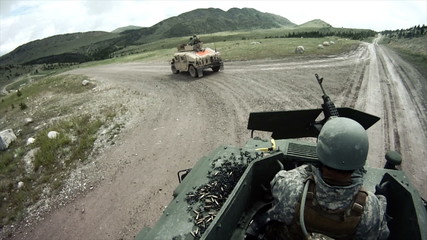 Military convoy approaches a hill