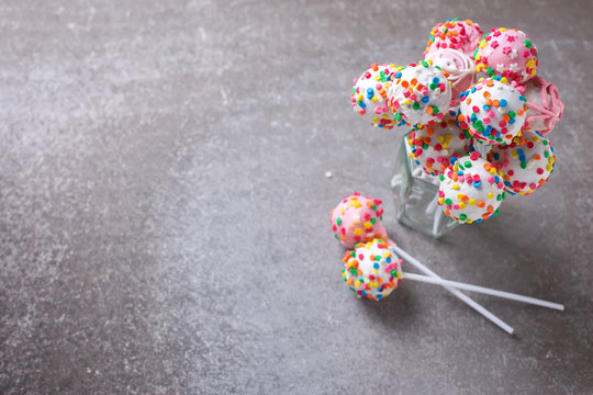 Cake pops can on grey slate background.