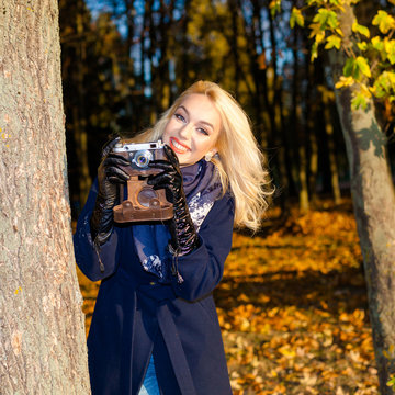 Hipster girl with vintage camera. modern hipster girl photographed using vintage camera. Outdoors lifestyle