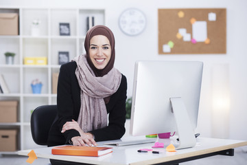 Beautiful Arabic business woman working on computer. Woman in her office,shallow depth of field