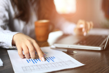 Hands of financial manager taking notes when working on report