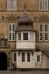 Detail of a Building. An old historical building with interesting decorations and a delightful cupola entrance sits in the main street of the town of Aalborg in Jutland, Denmark.