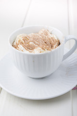 Hot chocolate garnished with whipped cream and cocoa powder.