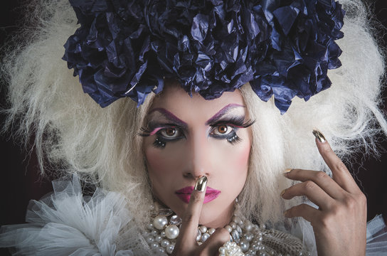 Drag queen with spectacular makeup, glamorous trashy look, posing while using hands and fingers