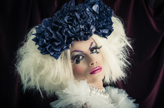 Drag queen with spectacular makeup, glamorous trashy look, posing happily and charming camera