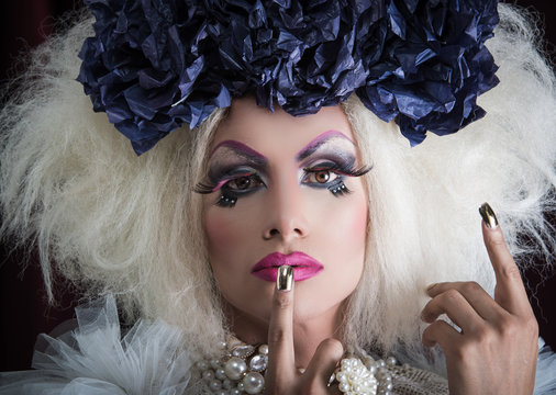 Drag queen with spectacular makeup, glamorous trashy look, posing serious facial expression
