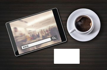 On line shopping on tablet screen with coffee cup and white busi