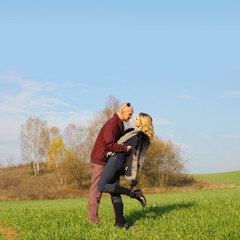 Naklejka na ściany i meble young beautiful couple having fun outdoors. Young happy couple outdoor portrait. Beautiful boy and girl have fun in the field.