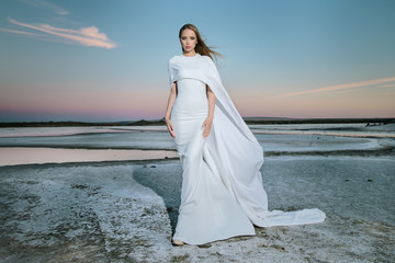 Fototapeta na wymiar Stunning young woman in white dress 