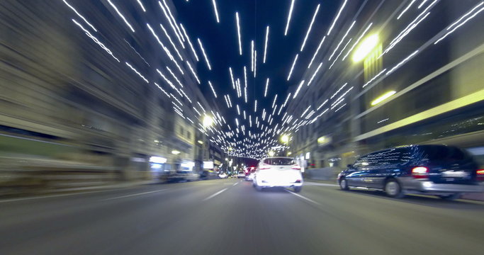 Driving after dark through the streets of Barcelona with Christmas lights. Time Lapse - Trail effect - vehicle shot - subjective view - 4K.(02)