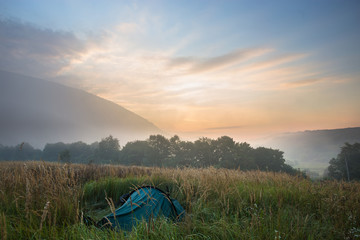 Mysterious fog in the tent camp at sunrise time