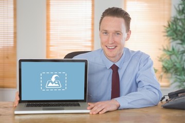 Composite image of happy businessman showing laptop screen