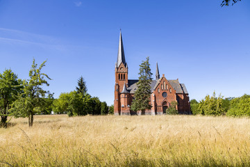 red brick church on a wild meadow