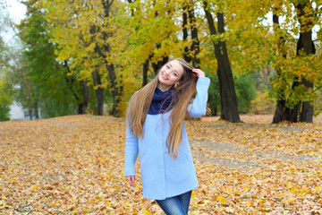 Cheerful and positive hipster girl having fun among autumn leaves.  Free woman enjoying freedom feeling happy. Hipster girl showing happy positive emotions
