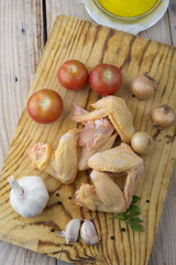 Fototapeta na wymiar Fresh raw chicken wings on a cutting board on rustic table