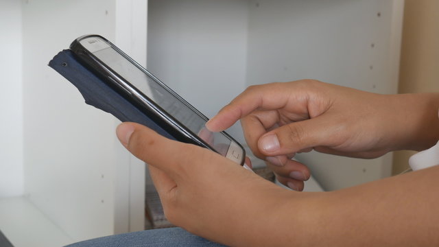 Close Up hand of lady to touching screen monitor of mobile phone to chat with friend 
