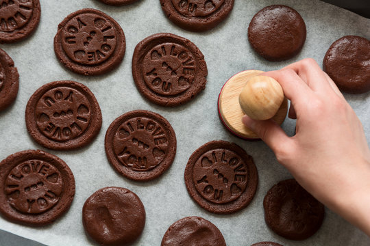 Preparing chocolate cookies with pressed text 'I love you'