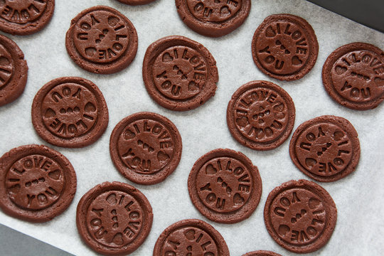 Preparing chocolate cookies with pressed text 'I love you'