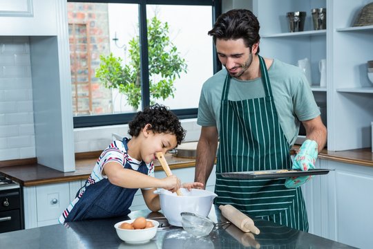 Smiling Father And Son Cooking Biscuits