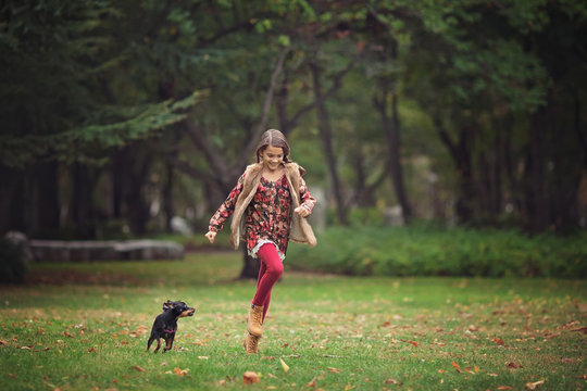 Girl chasing puppy dog in the park