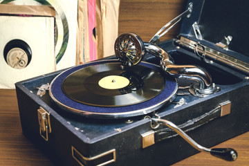 Gramophone with a vinyl record on wooden table