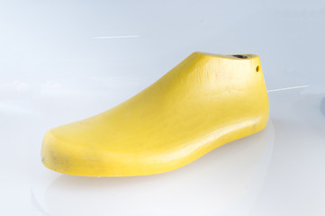 Yellow plastic last shoe rough surface from use on white background
