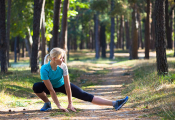 Runner woman training on forest road in beautiful nature