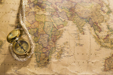 old compass and rope on vintage map