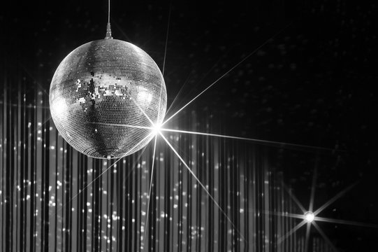 Party disco ball with stars in nightclub with striped walls lit by spotlight, nightlife entertainment industry, monochrome  