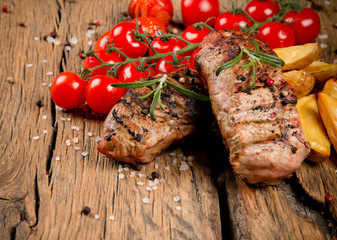 Grilled steaks on wooden table 