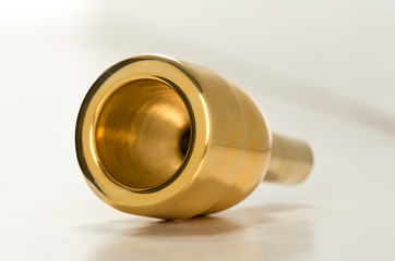 Obraz na płótnie Canvas Мouthpiece for trombone / Mouthpiece for trombone, golden color on a white background.