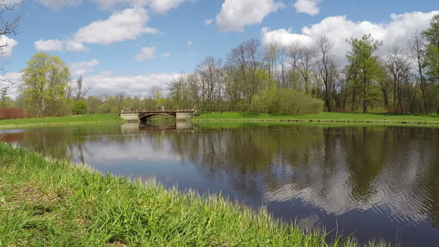 The small shabby bridge in park over a lake. time lapse with turn