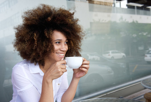 Smiling african american woman sitting with cup of coffee