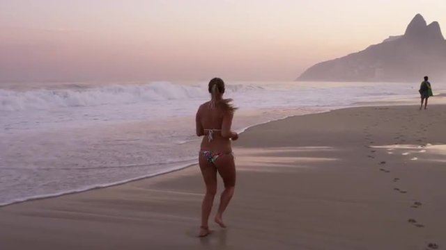 Woman jogging down Ipanema beach